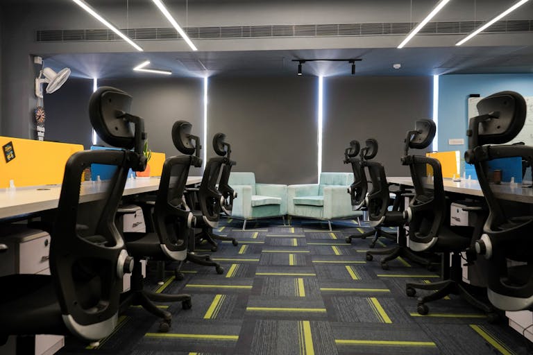 Spacious modern office with ergonomic chairs and bright decor, perfect for a productive work environment.